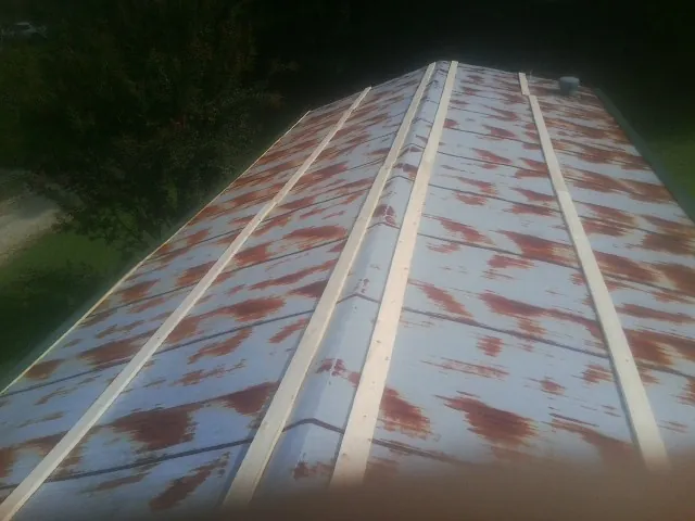 Rusted metal roof panels with new wood purlins before replacement — Storm Damage Roof Repair in Salem by Roofing Brothers